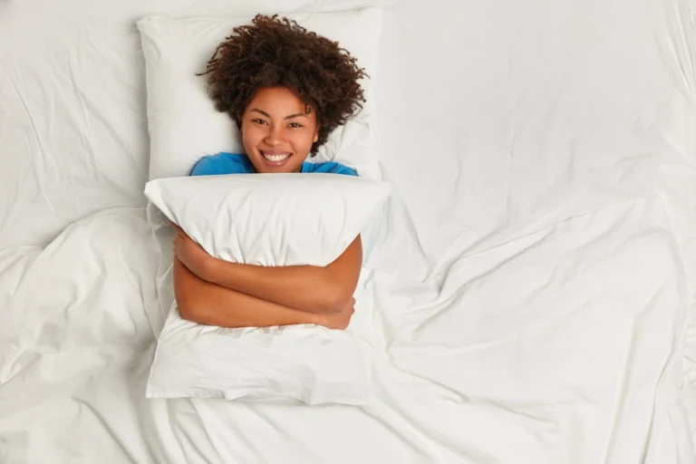 pessoa descansando na cama com travesseiro lencois brancos tecnicas para dormir melhor naturalmente 1