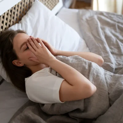 mulher cansada dormindo 6 horas deficit de sono cronico impactos no corpo