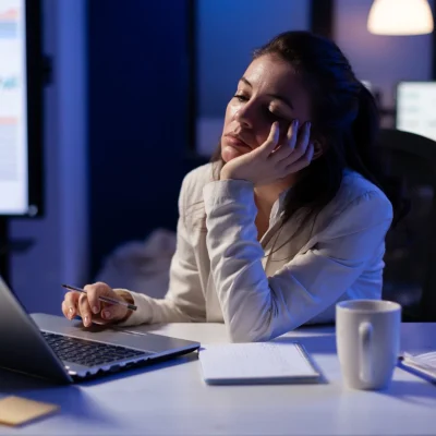 mulher trabalhando noite no escritorio telas notebook celular sono e produtividade qual a relacao